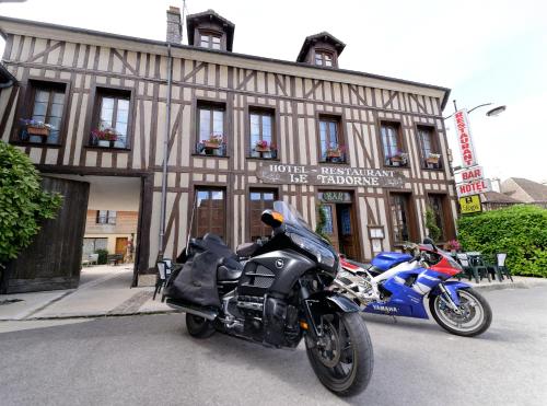 ein Motorrad, das vor einem Gebäude geparkt ist in der Unterkunft Logis Le Tadorne in Piney