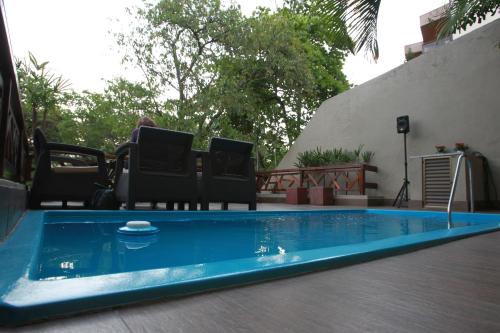 una piscina con 2 sillas y una persona sentada en una silla en Hangar Rio Hostel, en Río de Janeiro