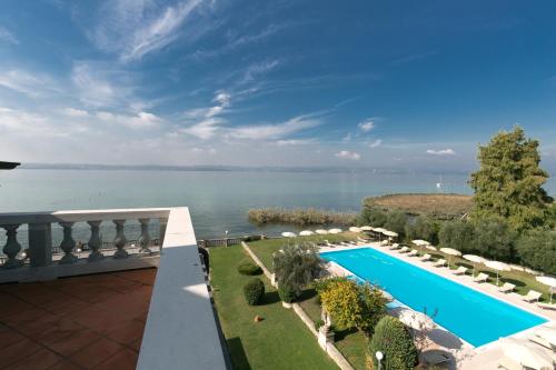 uma vista para a água a partir da varanda de uma casa em Villa Pioppi Hotel em Sirmione