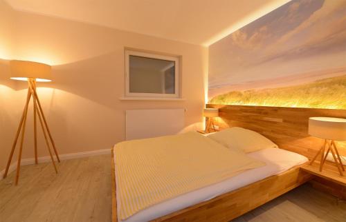 A bed or beds in a room at Wenningstedt Beach Apartment