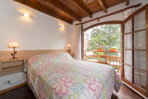 ein Schlafzimmer mit einem Bett und einem großen Fenster in der Unterkunft Cabañas Gonzalez in Villa Gesell