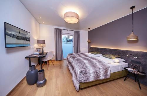 een grote slaapkamer met een groot bed en een bureau bij TWO TIMEZ - Boutique Hotel in Zell am See