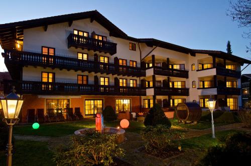 ein großes Gebäude mit nachts eingeschaltetem Licht in der Unterkunft Hotel Hirsch in Oberstaufen