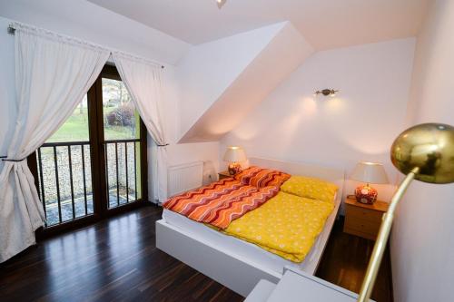 a bedroom with a bed and a large window at Sweet Family Home in Cieszyn