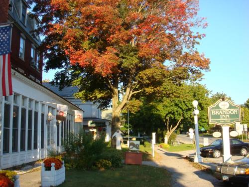 un cartello stradale di fronte a una casa con un albero di The Brandon Inn a Brandon