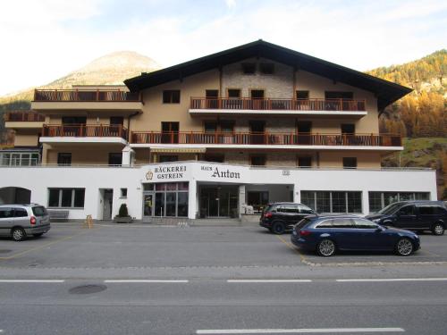 un grande edificio con auto parcheggiate in un parcheggio di Haus Anton Sölden - Apartments & Zimmer a Sölden