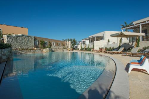 einen Pool mit blauem Wasser in einem Resort in der Unterkunft Borgo de li Santi in Otranto