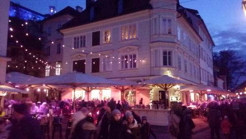 a crowd of people standing in front of a building at 3 Bridges App in Ljubljana