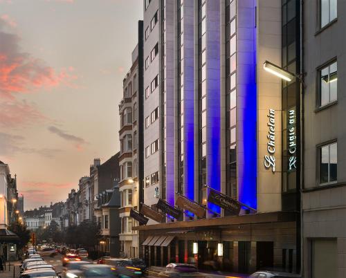 a city street with cars parked in front of a building at Hotel Le Châtelain in Brussels