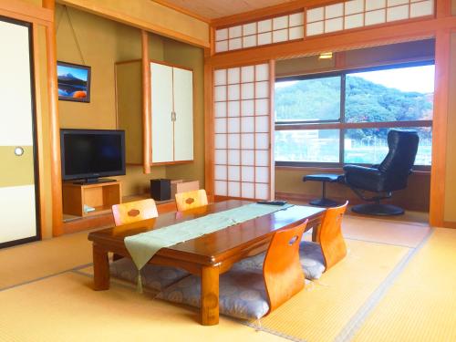 - un salon avec une table en bois et une chaise dans l'établissement Hoshi Meguri, à Shimoda