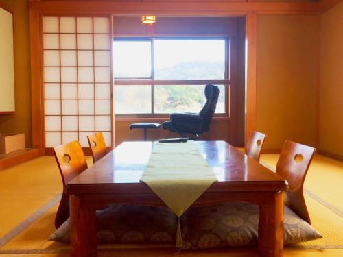 - une table et des chaises dans une chambre avec fenêtre dans l'établissement Hoshi Meguri, à Shimoda