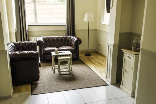 a living room with two chairs and a table at Hotel Saint Georges in Mons