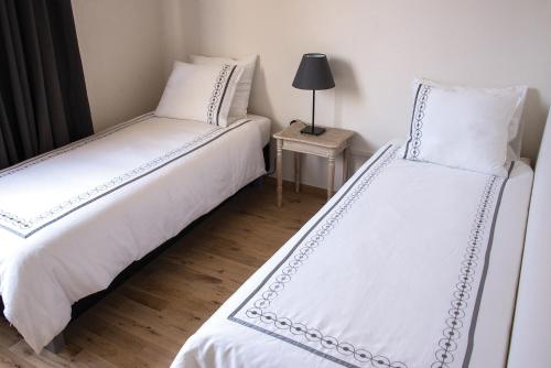 two beds sitting next to each other in a room at Hotel Saint Georges in Mons