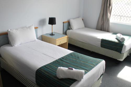 um quarto de hotel com duas camas e uma janela em Rocky Glen Hotel Motel Gladstone em Gladstone