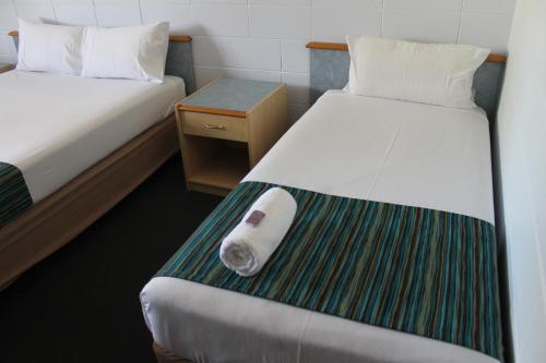 um quarto de hotel com duas camas e uma toalha na cama em Rocky Glen Hotel Motel Gladstone em Gladstone