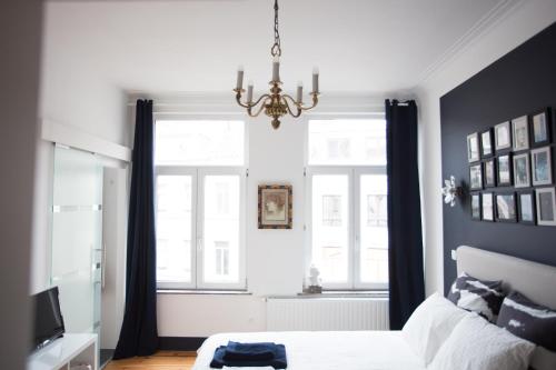 - une chambre avec un lit et un lustre dans l'établissement B&B Villa 36, à Bruxelles