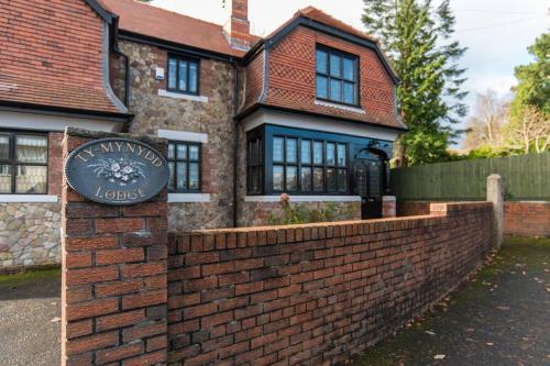 eine Backsteinmauer vor einem Haus in der Unterkunft Ty Mynydd Lodge Holiday Home in Cardiff