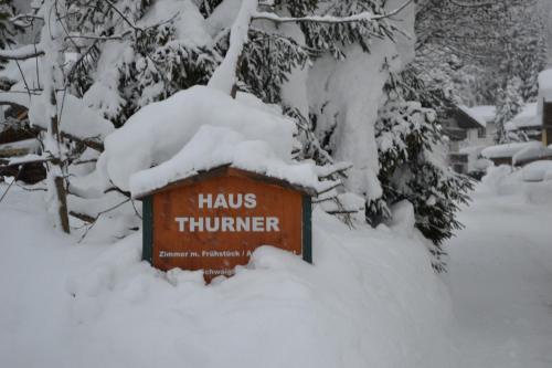 un panneau est recouvert de neige dans une cour dans l'établissement Haus Thurner, à Wagrain