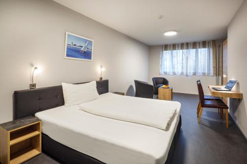 Aparthotel-aarau-WEST Swiss Quality في Oberentfelden: غرفة في الفندق مع سرير ومكتب