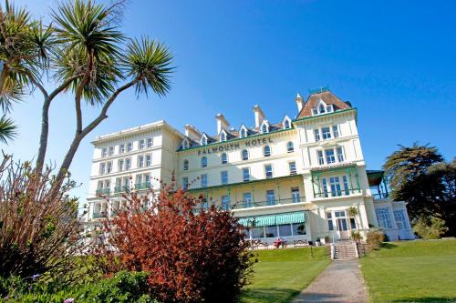 um grande edifício branco com palmeiras em frente em The Falmouth Hotel em Falmouth