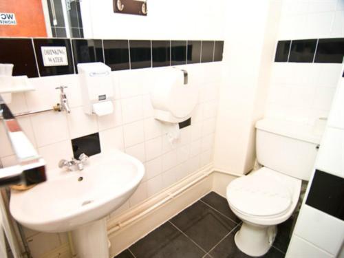 een witte badkamer met een toilet en een wastafel bij Skylark Guest House in Hounslow