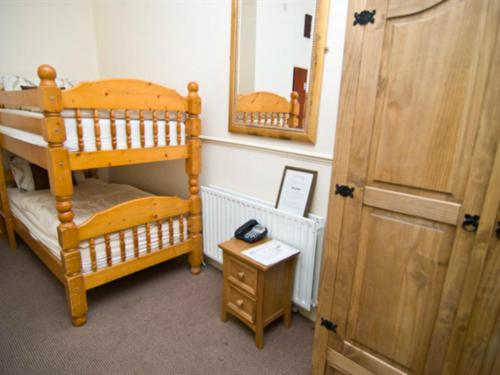 een kamer met een houten stapelbed en een spiegel bij Skylark Guest House in Hounslow