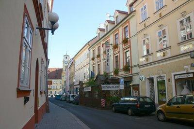 eine Stadtstraße mit Autos, die vor den Gebäuden geparkt sind in der Unterkunft Hotel Barbarossa in Cheb