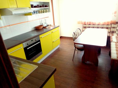 een keuken met een tafel en gele kasten bij Penzión Reduta in Oravský Podzámok