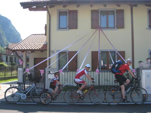 un gruppo di persone che vanno in bicicletta davanti a una casa di B&B AI PELLEGRINI a Villa Santina