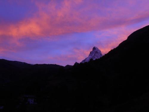 een berg tegen een paarse en rode hemel bij zonsondergang bij Chalet Kolibri in Zermatt