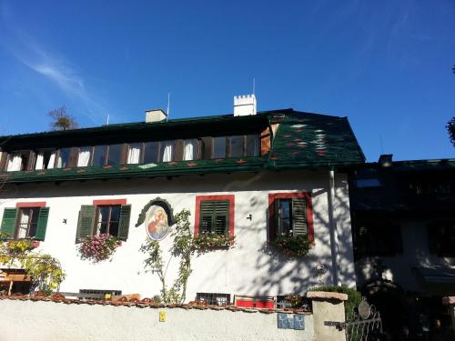 a white building with red shutters and flowers on it at Haus Wartenberg in Salzburg