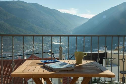 - une table en bois avec une tasse sur le balcon dans l'établissement Casa Mariolas, à Manteigas