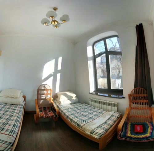 um quarto com duas camas e duas cadeiras e uma janela em Hostel MIF em Ivano-Frankivsk