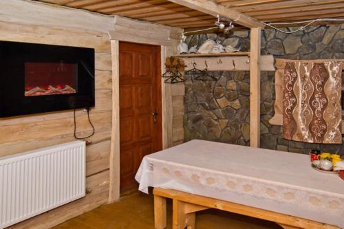 een houten kamer met een tafel en een open haard bij Smerichka Hotel in Dragobrat