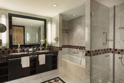 a bathroom with a tub and a sink and a shower at Maritim Hotel Dresden in Dresden