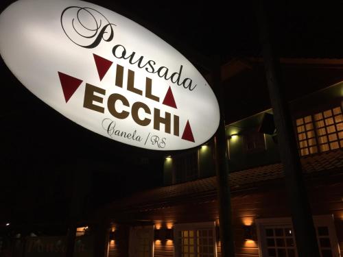 a sign for anushka villa resort at night at Pousada Villa Vecchia in Canela