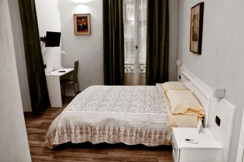 een witte slaapkamer met een bed en een bureau bij Flaneur in Turijn