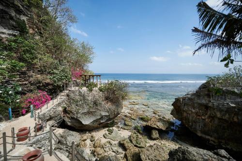 una scala che conduce alla spiaggia con l'oceano di The Island Houses Bingin a Uluwatu