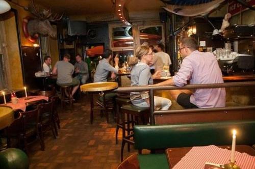 um grupo de pessoas sentadas num bar num restaurante em Hemingway`s Heidelberg Hostel em Heidelberg