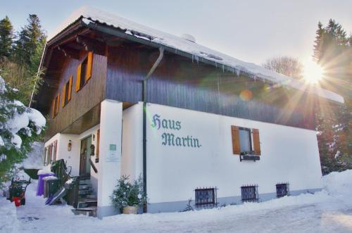 un edificio con un cartello sopra nella neve di Apartments Haus Martin a Bayerisch Eisenstein