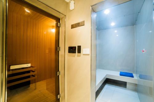 a shower in a bathroom with a glass door at Citadines OMR Chennai in Chennai