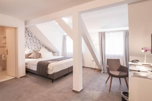 una camera con letto, scrivania e sedia di Hofgut Dippelshof Hotel- und Restaurant KG a Darmstadt