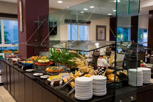 een buffet met borden en eten in een hotel bij Quality Hotel Curitiba in Curitiba