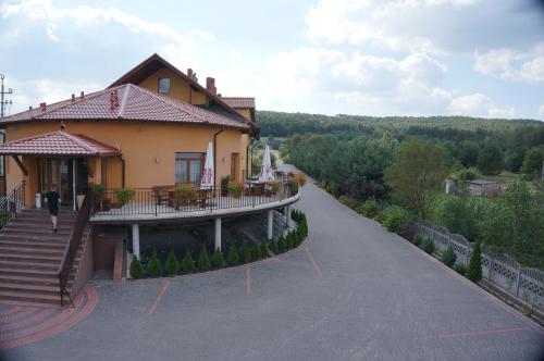 een huis met een balkon aan een weg bij Hotel & Restauracja Okrąglak in Chęciny