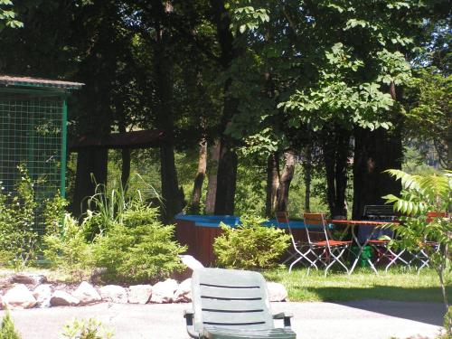 une paire de chaises blanches assises dans un jardin dans l'établissement Hotel Sternen, à Lenzkirch