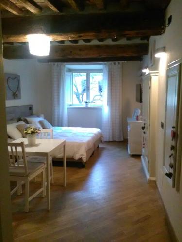 1 dormitorio con cama, mesa y ventana en Suite Sofia, en Lucca