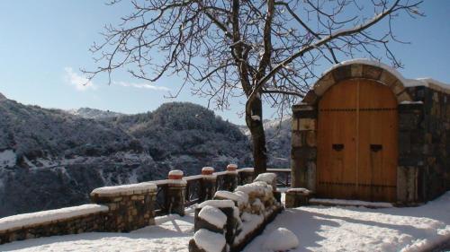 um edifício com uma porta de madeira na neve em Agnantio studios & suites em Lagadia