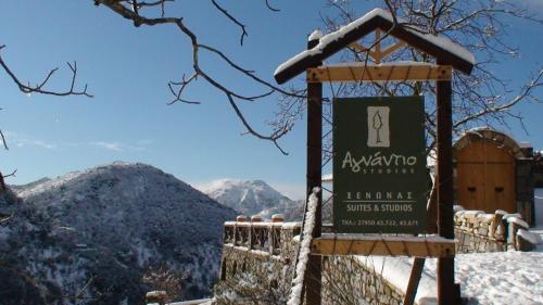 um sinal na neve com montanhas ao fundo em Agnantio studios & suites em Lagadia