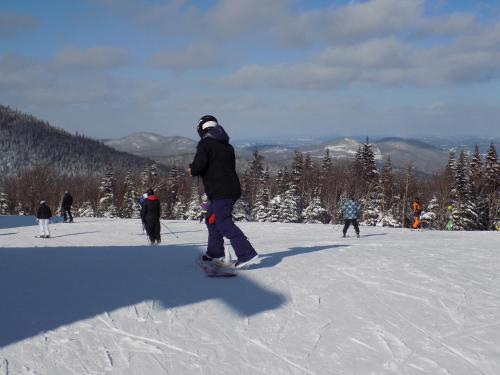 une personne faisant du snowboard sur une piste enneigée dans l'établissement Gîte Esprit Follet, à Baie-Saint-Paul