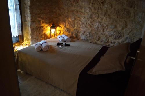 - une chambre avec un lit doté d'oreillers blancs dans l'établissement Niko's Stone Guest House, à Plitra